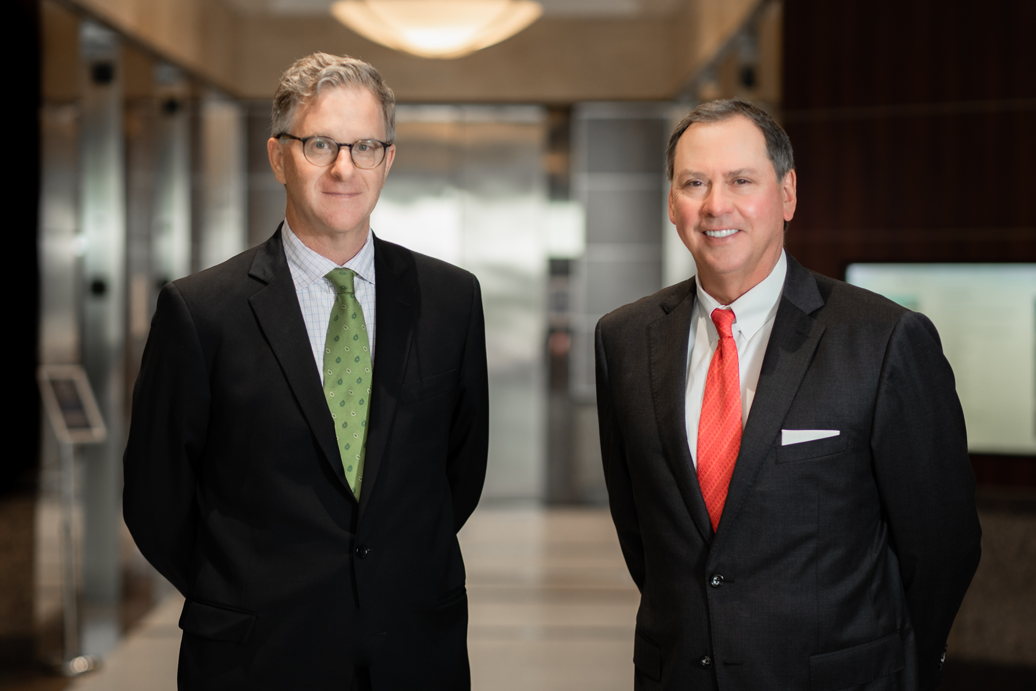 Attorneys Greg Evans and Mitch Toups standing in an office lobby
