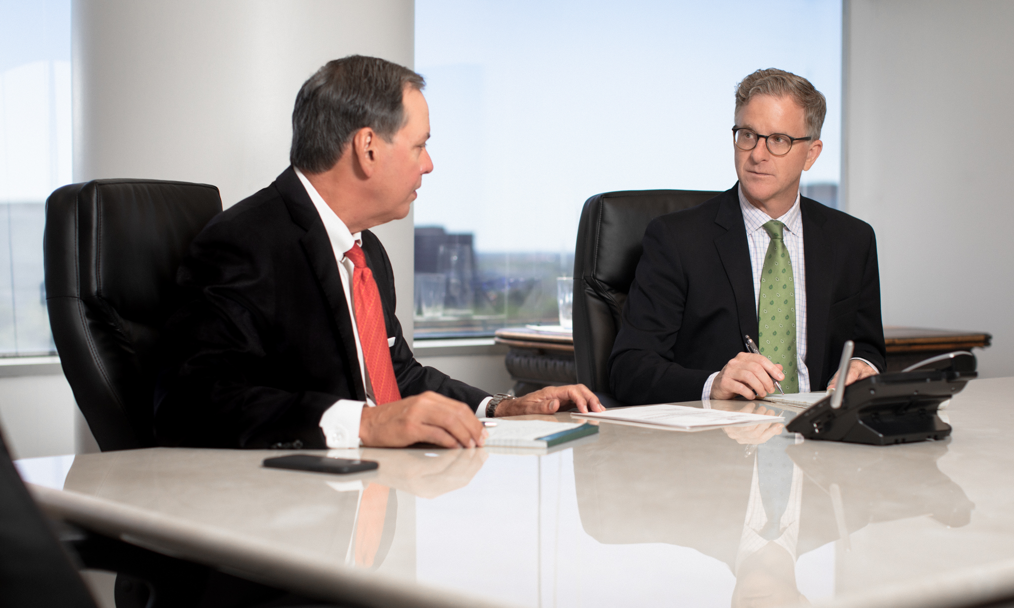 Attorneys Mitch Toups and Greg Evans meeting in a conference room