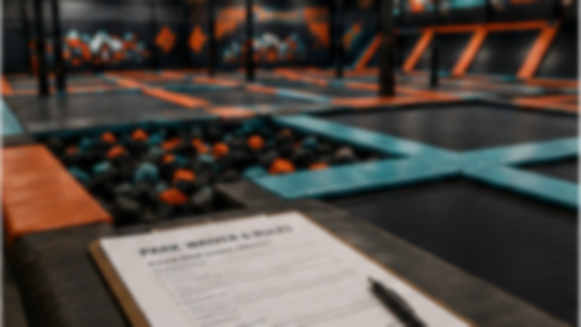 Soft-focus paperwork in front of an indoor trampoline park